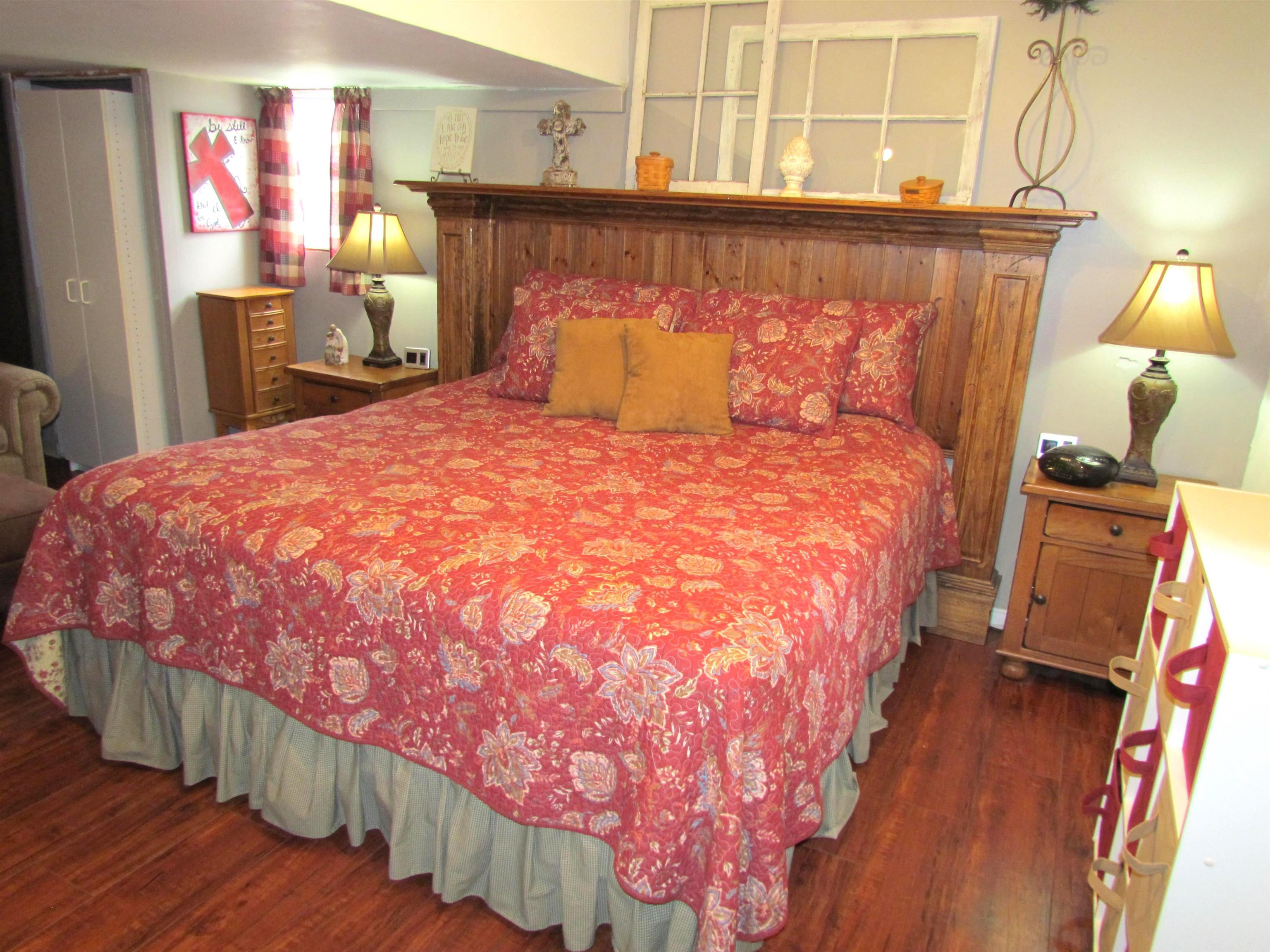 727 Elgin Street Cherry Valley, IL 61016 - Photo 21 of 35 a bed sitting in a bedroom next to a window with wooden floor