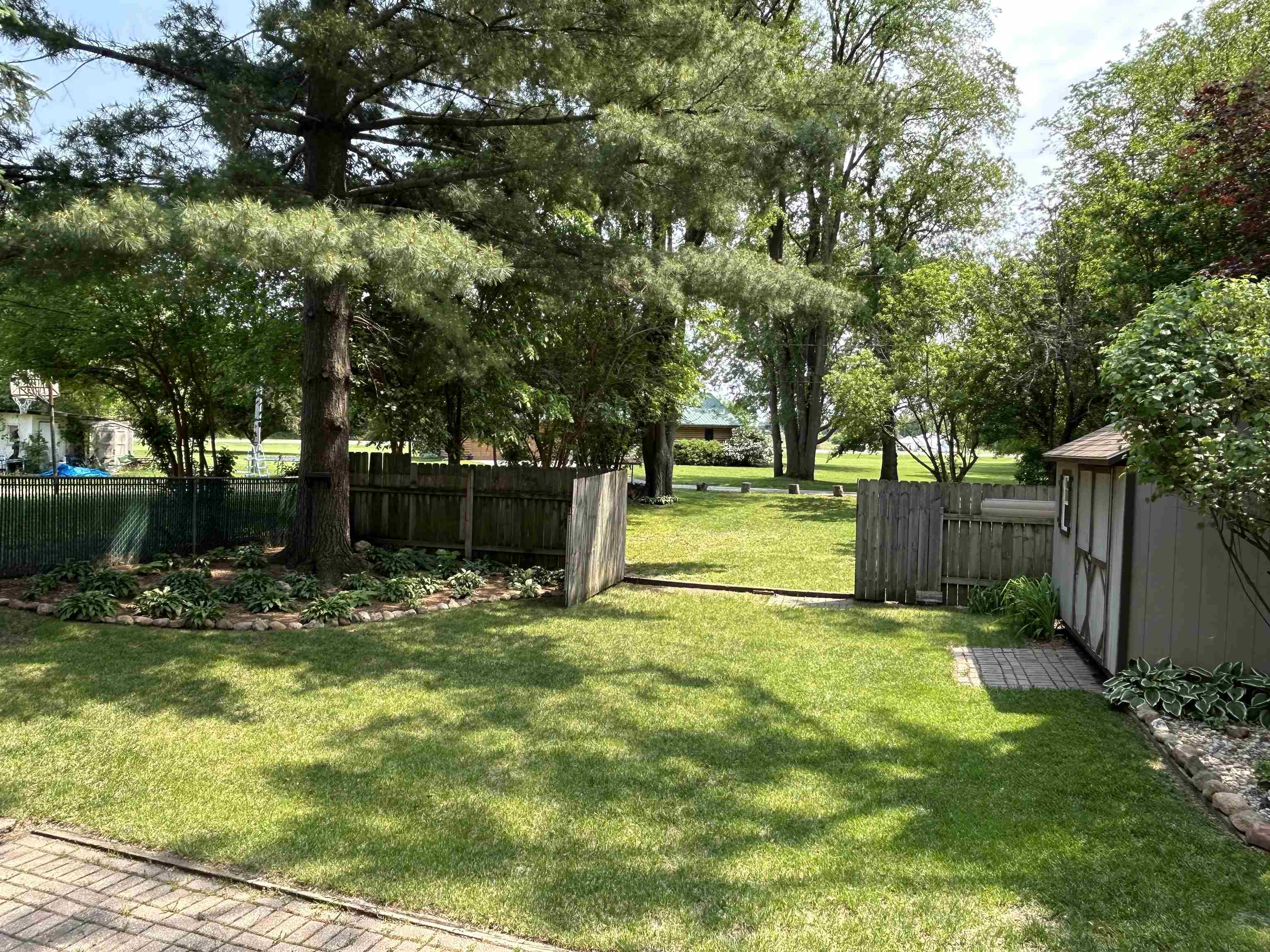 727 Elgin Street Cherry Valley, IL 61016 - Photo 30 of 35 a view of a yard with plants and large trees