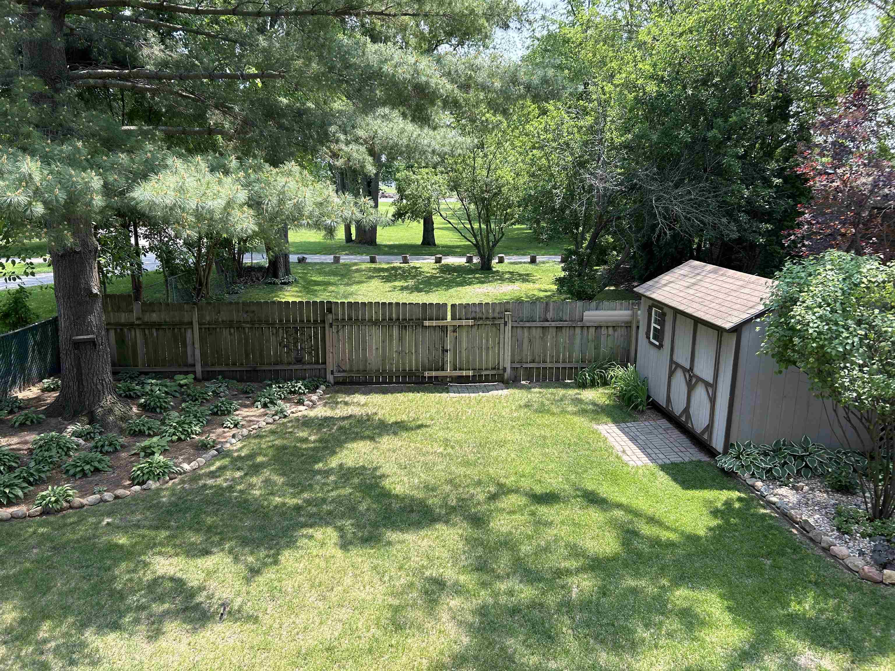 727 Elgin Street Cherry Valley, IL 61016 - Photo 4 of 35 a view of a backyard with a garden and trees