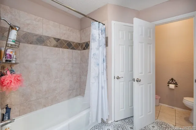 a bedroom with a bed and a flat tv screen on a dresser