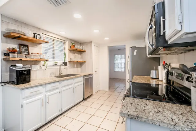 a kitchen with stainless steel appliances a refrigerator stove microwave and sink
