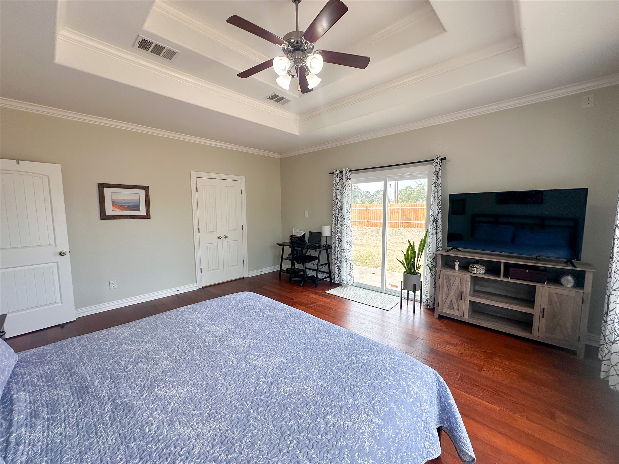 237 Cardinal Drive Paige, TX 78659 - Photo 13 of 37 Bedroom with access to outside, dark wood finished floors, a ceiling fan, a tray ceiling, and a closet