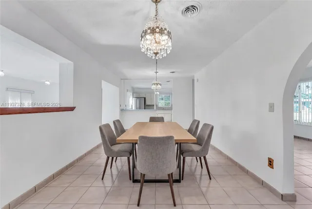 a view of a dining room with furniture and chandelier