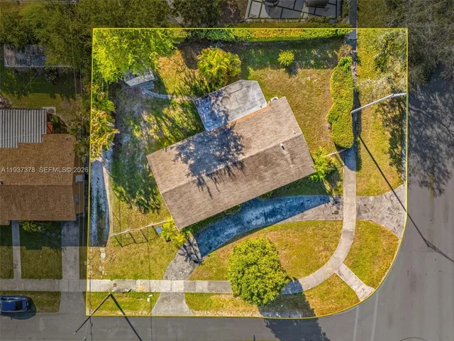 an aerial view of a swimming pool with outdoor seating and yard