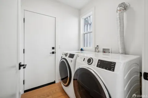 a view of washer and dryer with kitchen in the background
