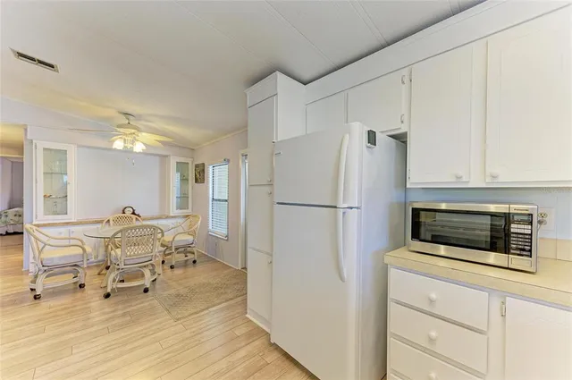 a living room with furniture and a refrigerator