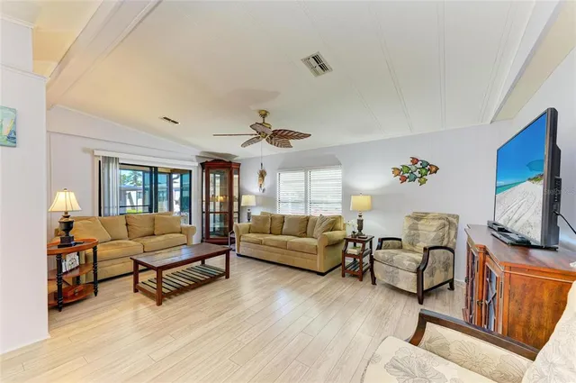 a living room with furniture and a flat screen tv with wooden floor