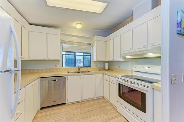 a kitchen with granite countertop white cabinets and white appliances