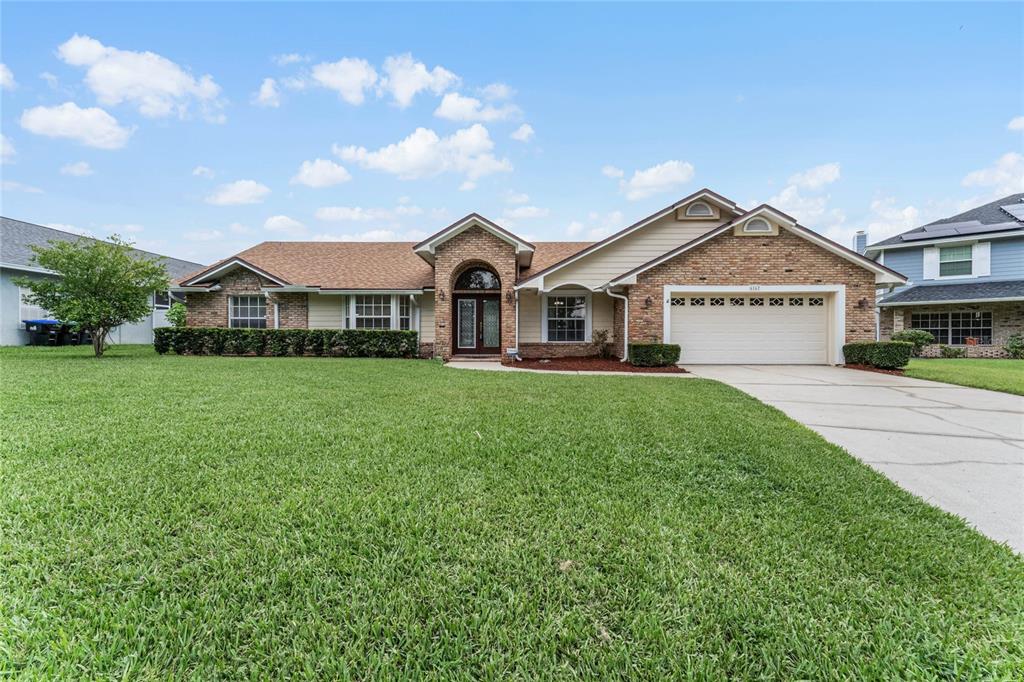 6167 Sand Pines Estates Boulevard Orlando, FL 32819 - Photo 1 of 61 a front view of a house with a garden and plants