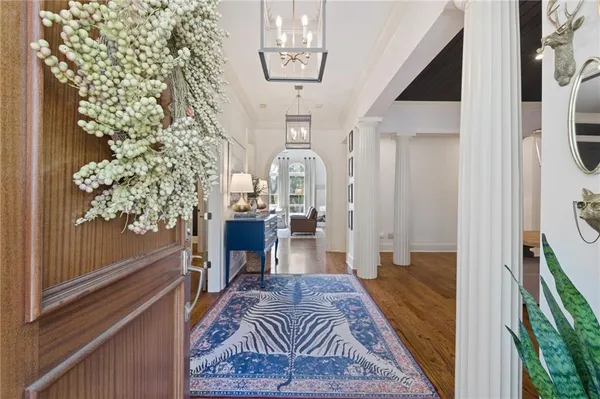 a dining room with furniture a chandelier and wooden floor
