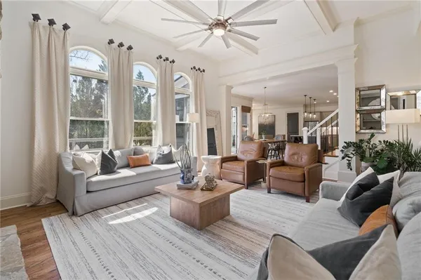 a view of a dining room and livingroom with furniture wooden floor a chandelier