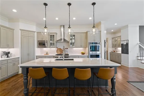 a large kitchen with kitchen island a dining table and chairs
