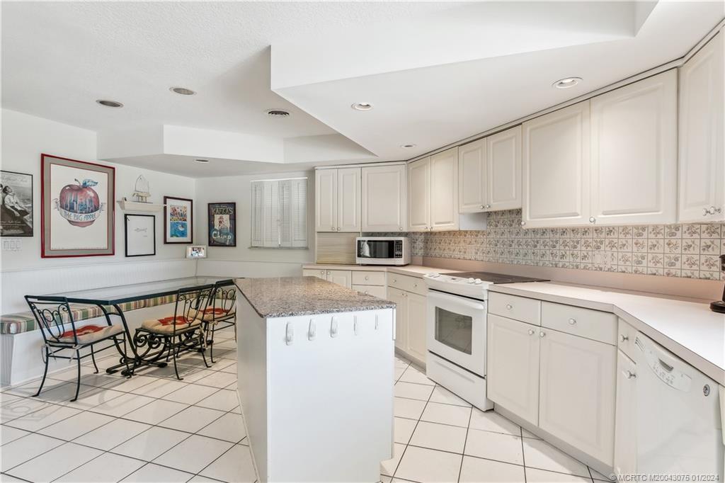 32 North River Road Sewall's Point, FL 34996 - Photo 14 of 27 a kitchen with cabinets and chairs