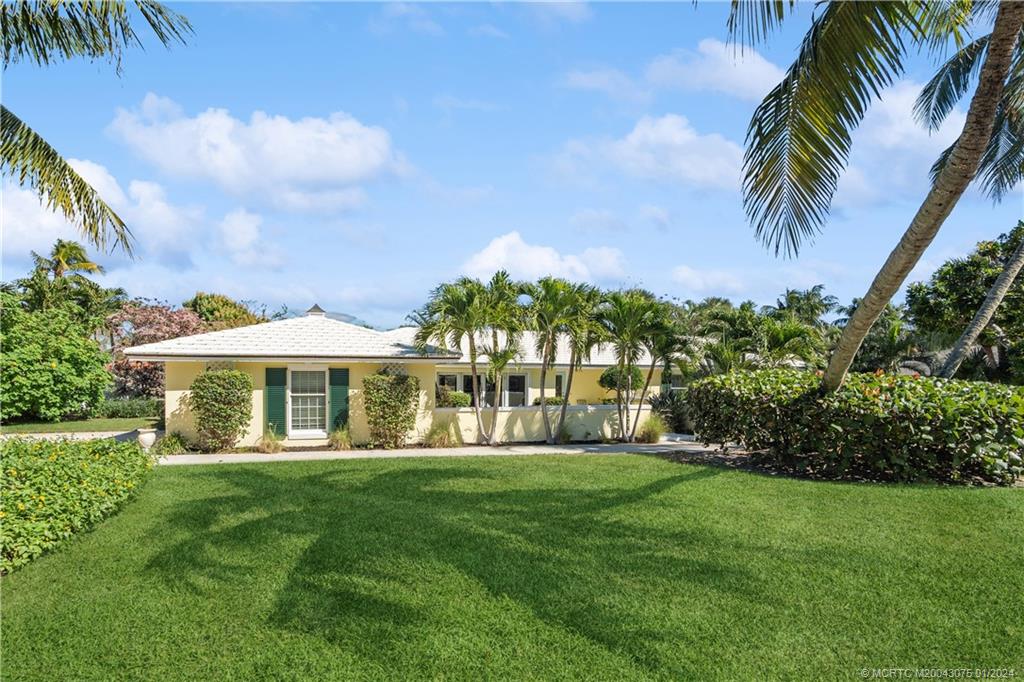 32 North River Road Sewall's Point, FL 34996 - Photo 4 of 27 a view of a house with a big yard and palm trees