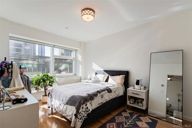 a bedroom with a bed table and a flat screen tv