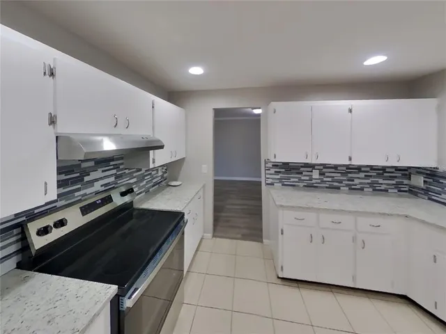 a kitchen with granite countertop a stove and a sink