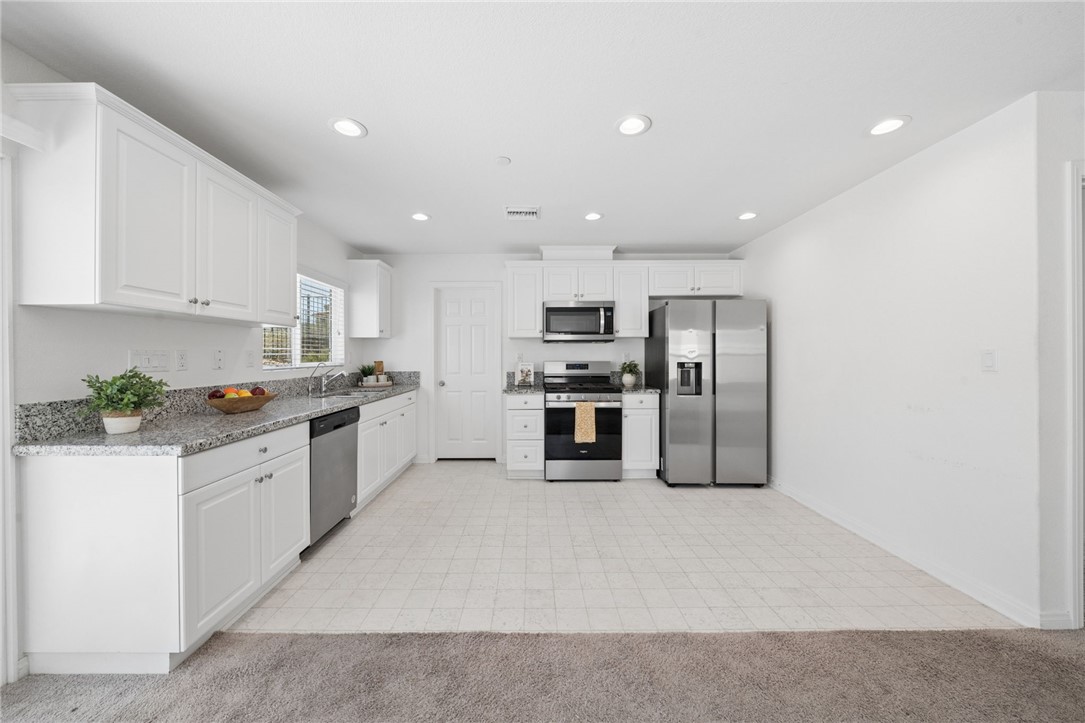 20130 Curaco Court Riverside, CA 92507 - Photo 15 of 43 Bright kitchen with ample cabinetry, stainless appliances, and dining space.