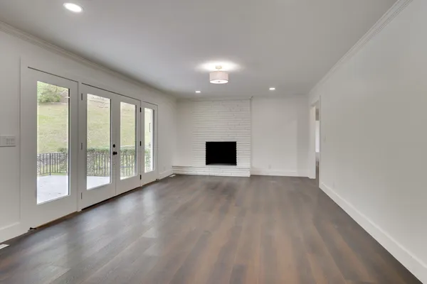 a view of empty room with wooden floor and fireplace