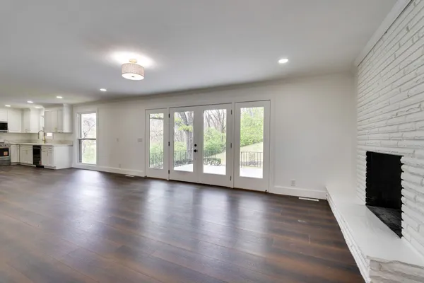 an empty room with wooden floor and a fireplace