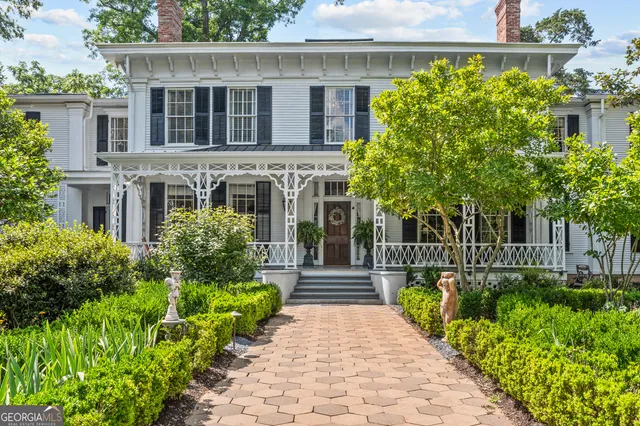 a front view of a house with a yard and potted plants