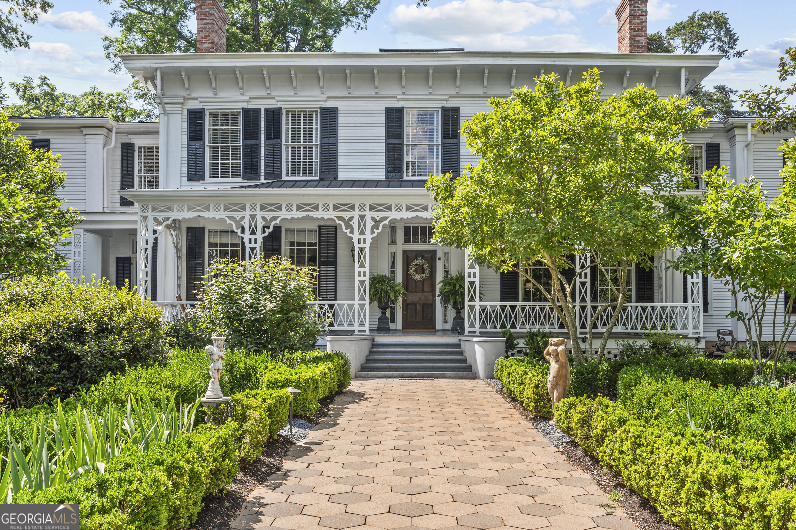 a front view of a house with a yard and potted plants