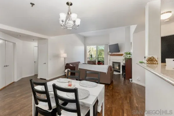 a view of a dining room with furniture a chandelier and wooden floor