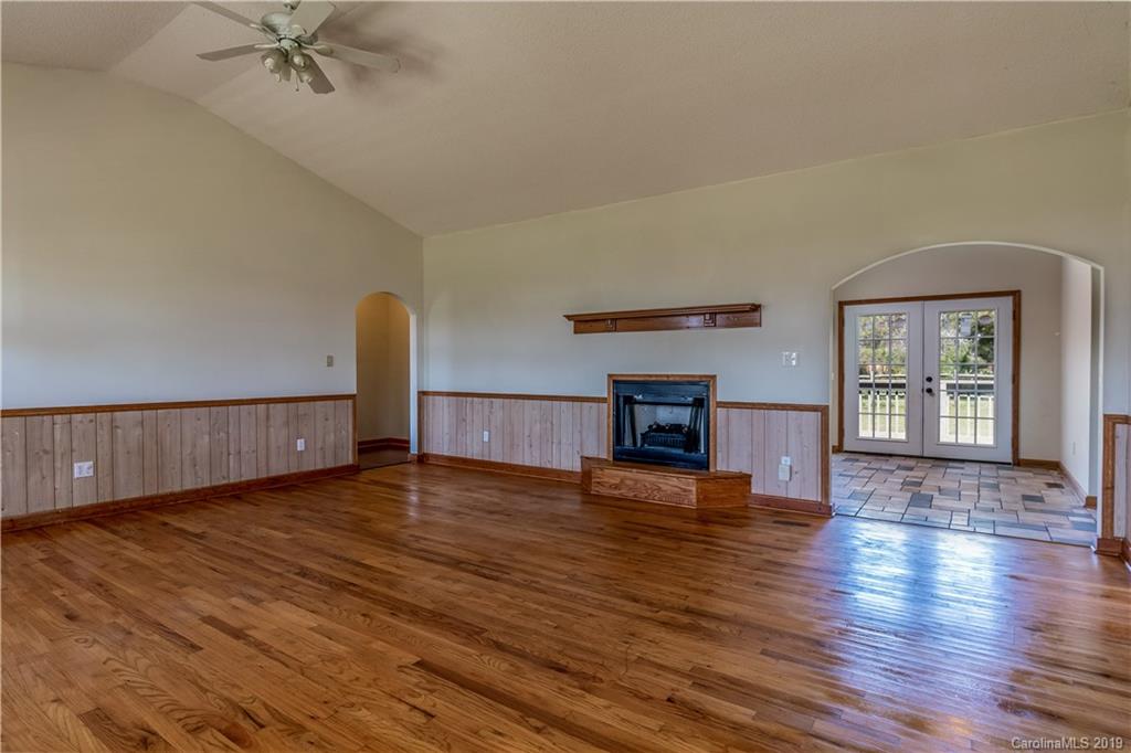 4501 Rowell Road Lancaster, SC 29720 - Photo 4 of 39 a view of a livingroom with wooden floor a ceiling fan and windows