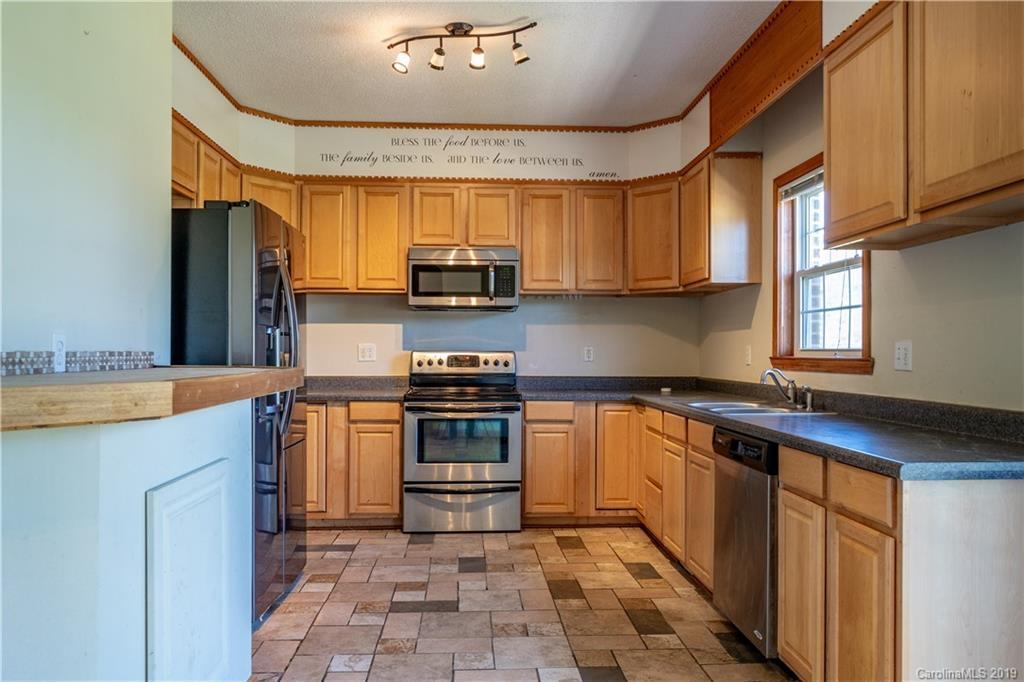 4501 Rowell Road Lancaster, SC 29720 - Photo 5 of 39 a kitchen with stainless steel appliances granite countertop a sink a stove a refrigerator cabinets and a window