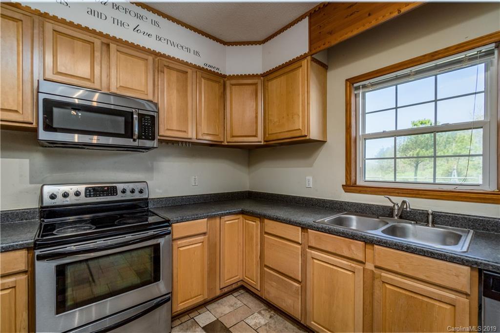 4501 Rowell Road Lancaster, SC 29720 - Photo 6 of 39 a kitchen with stainless steel appliances wooden cabinets stove and a sink