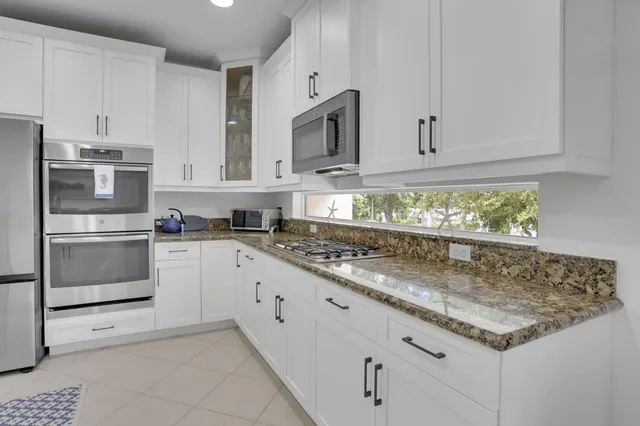 a kitchen with a refrigerator sink and white cabinets