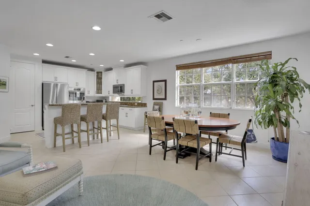 a dining room with furniture and a floor to ceiling window