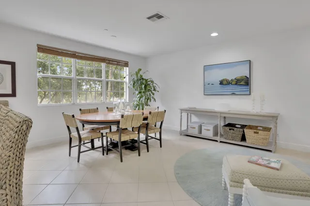 a kitchen with white cabinets and chairs