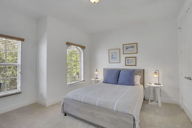 a bedroom with a bed and next to a window