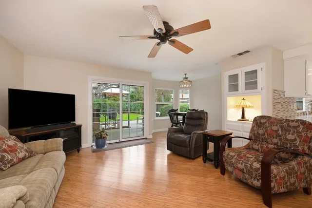 a living room with furniture a flat screen tv and a large window