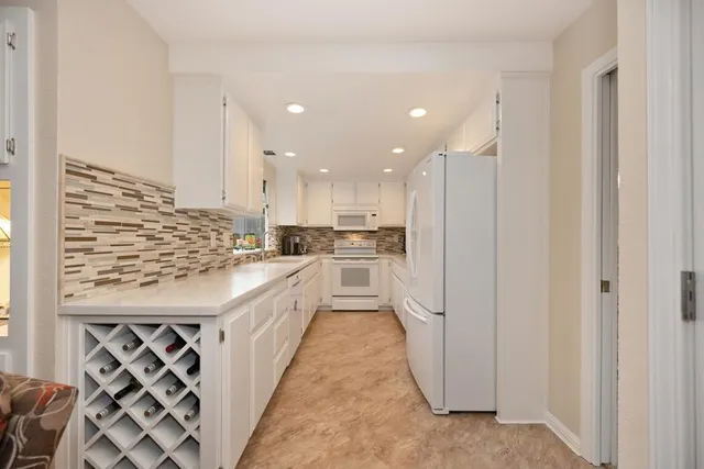 a kitchen with stainless steel appliances kitchen island granite countertop a refrigerator a sink and a stove