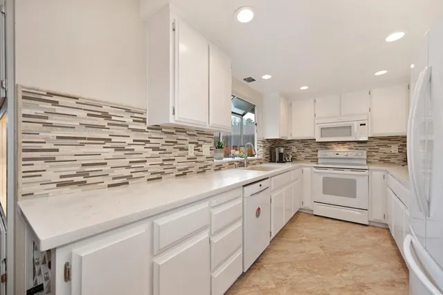 a kitchen with stainless steel appliances granite countertop a sink and cabinets with wooden floor