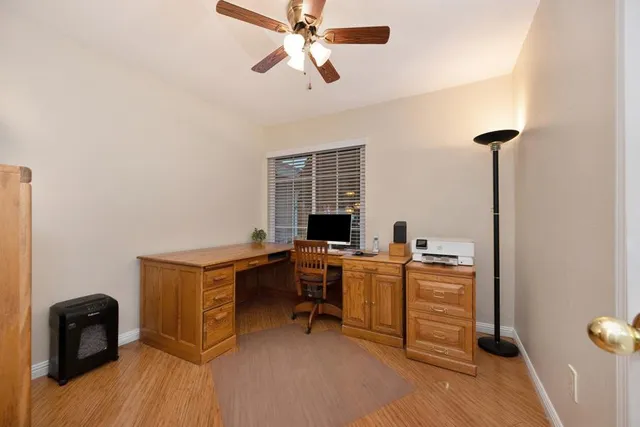 a view of a workspace with furniture and a window