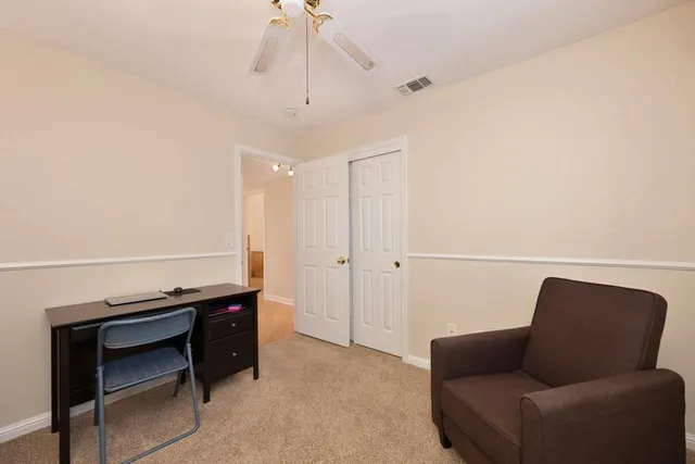 a living room with furniture a ceiling fan and a rug