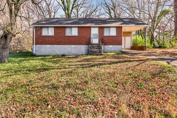 a front view of a house with a garden and yard
