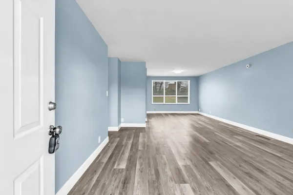 a view of a room with wooden floor and a window