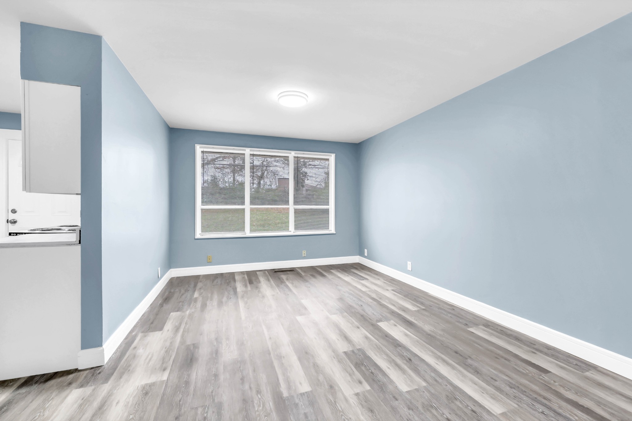 124 Yorktown Road Clarksville, TN 37042 - Photo 6 of 27 a view of an empty room with wooden floor and a window