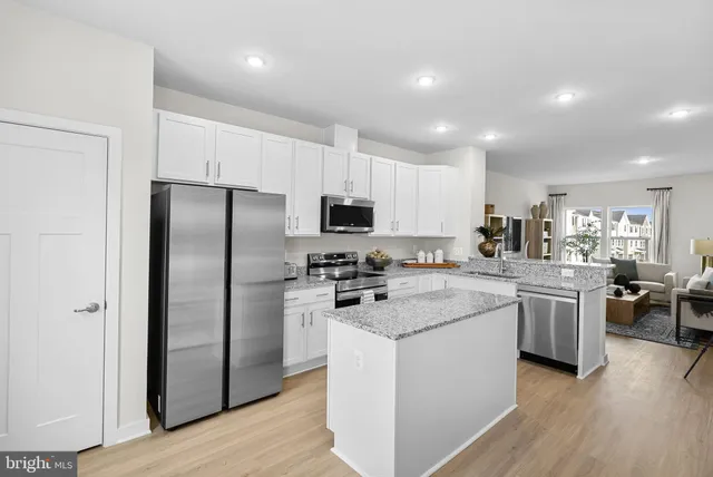 a kitchen with stainless steel appliances granite countertop a refrigerator stove microwave and sink