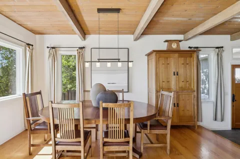 a dining room with furniture a chandelier and wooden floor