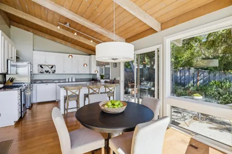 a view of a dining room with furniture a chandelier and wooden floor