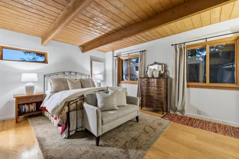 a bedroom with bed and wooden floor