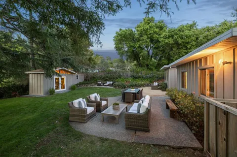 a backyard of a house with yard table and chairs