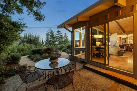 aerial view of a house with a yard and large trees