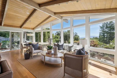 a living room with furniture and floor to ceiling windows