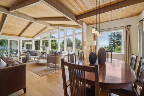 a view of a dining room with furniture large windows and wooden floor