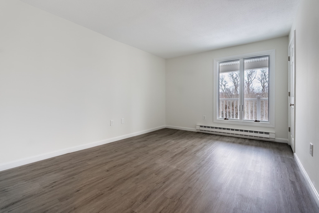 42 Old Colony Way, Unit 29 Orleans, MA 02653 - Photo 9 of 18 a view of an empty room with wooden floor and a window